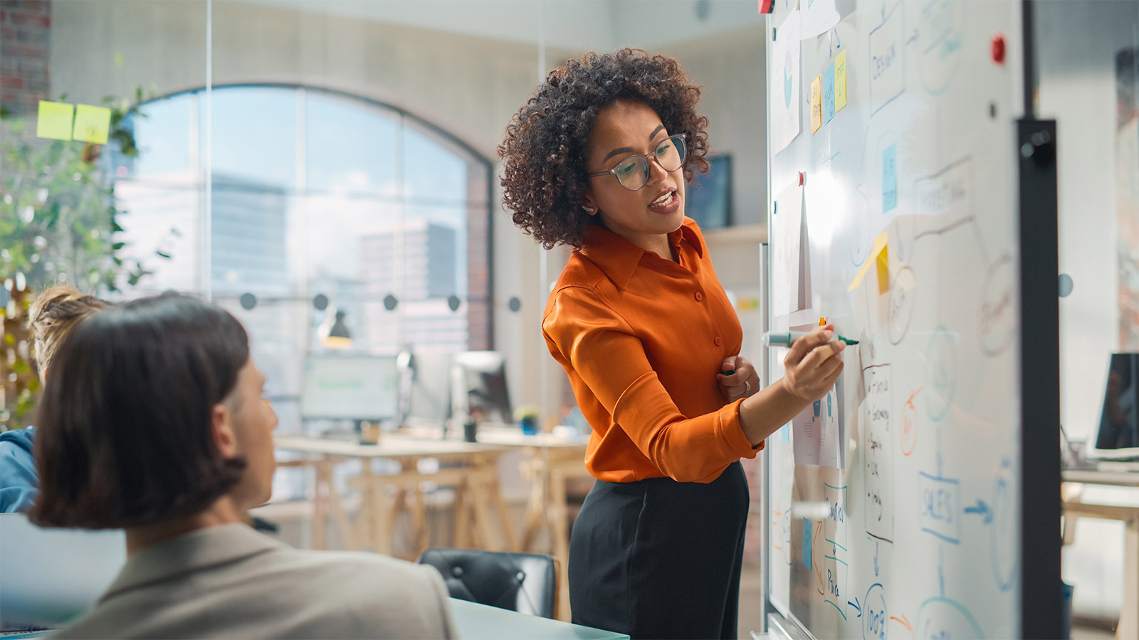 woman writing on meeting room board